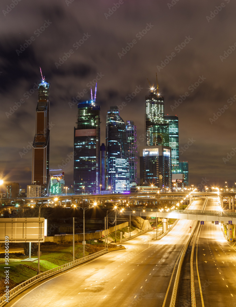 Night road and skyscrapers