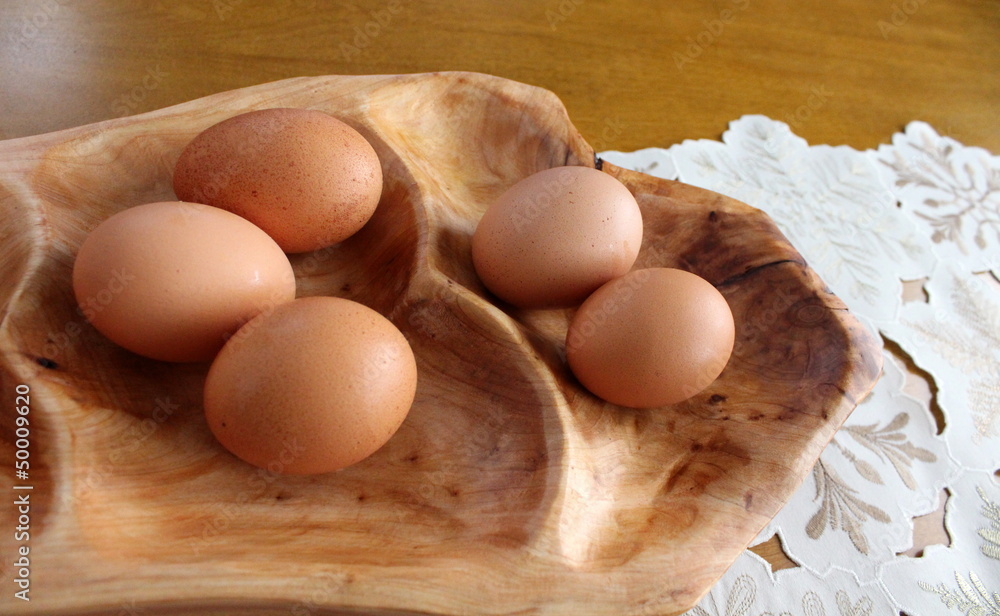 Fresh eggs on carved wood platter Fresh eggs on carved wood platter