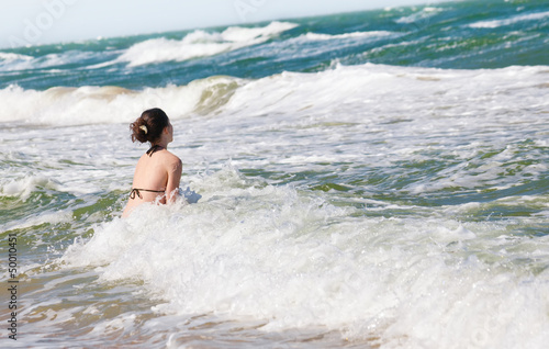 Happy girl splashing in the waves