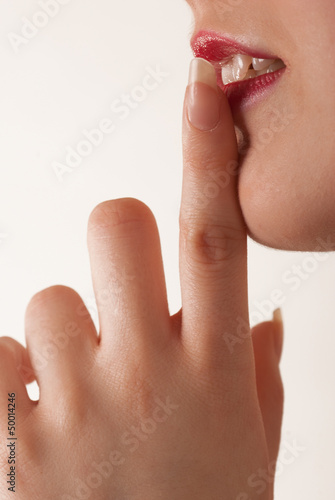 Kobieta trzymająca palec wskazujący przy ustach
