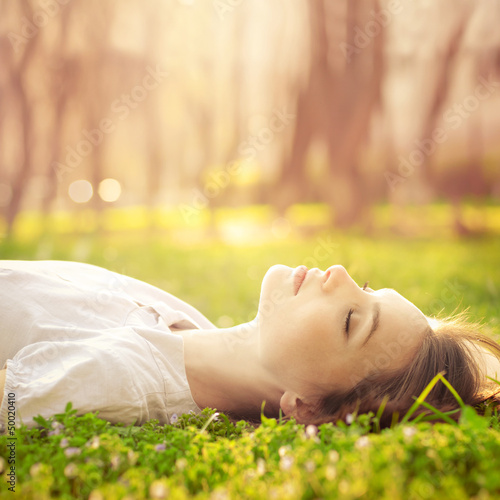 beautiful girl relaxing lying on the grass in the garden