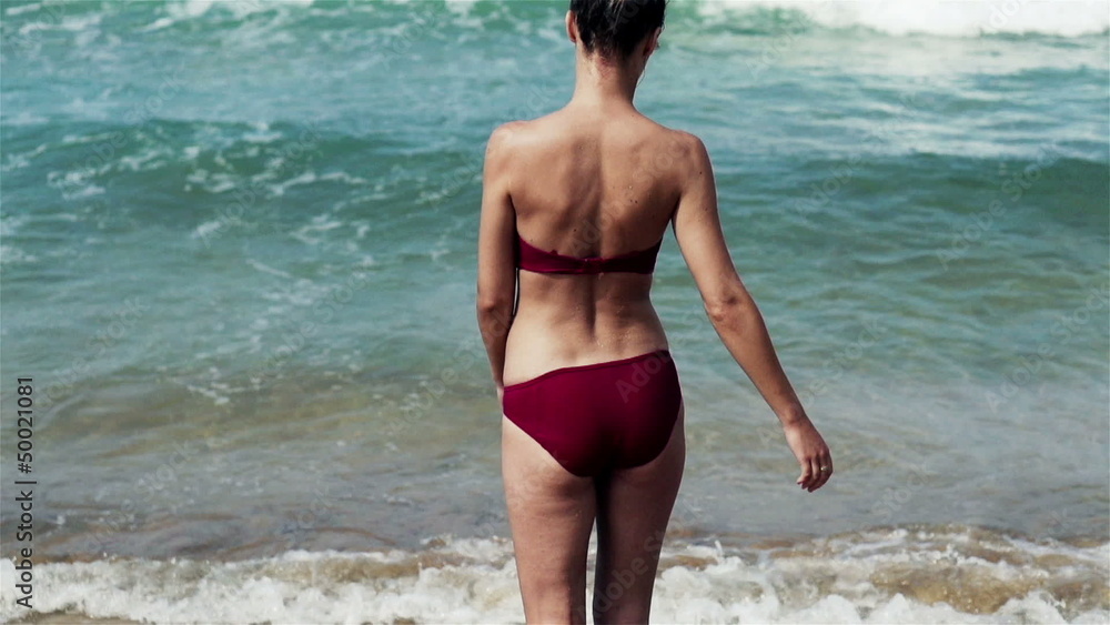 Woman walking on the beach, slow motion shot at 240fps Woman walking on the beach, slow motion shot at 240fps