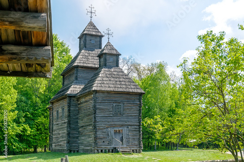 A typical antique Ukrainian orthodox wooden country church with a wooden roof, in the countryside near Kiev 