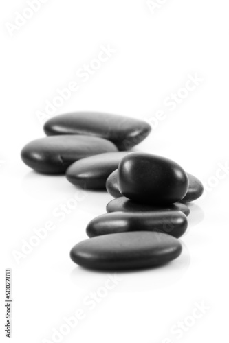 Black massage stones stacked  isolated.