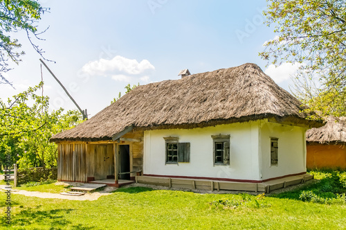 A typical antique Ukrainian country house or farm with a thatch roof, in the countryside near Kiev	