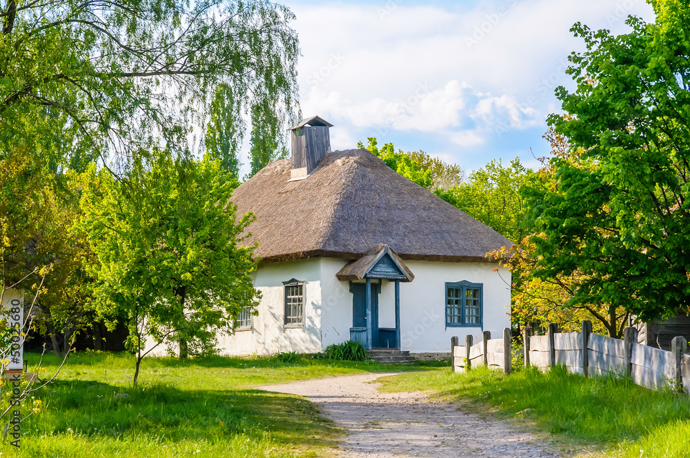 A typical antique Ukrainian country house with a thatch roof, in the countryside near Kiev	