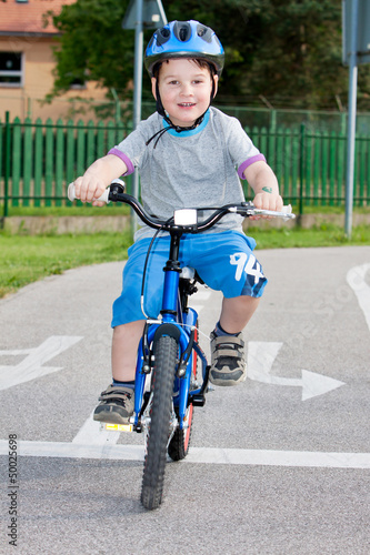 Fototapeta Naklejka Na Ścianę i Meble -  Baby boy on traffic playground for childs with crash helmet