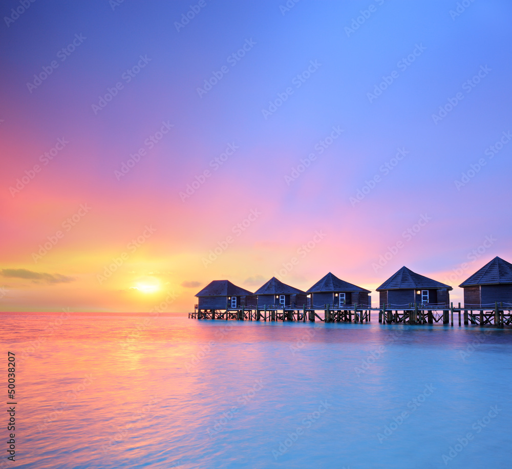 Naklejka premium View of a beautiful sunset on a Malidves island and water villas