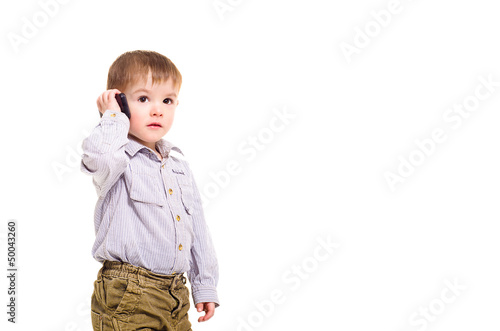 Beautiful little boy talking on a mobile phone