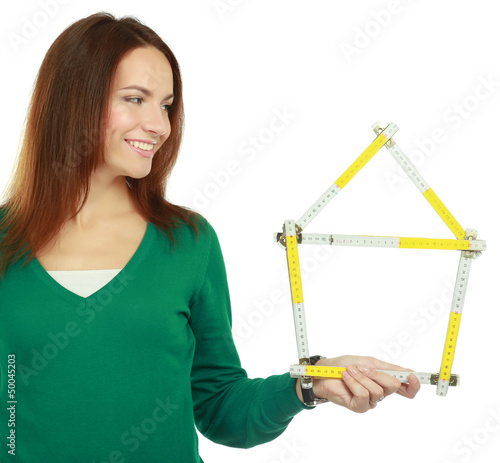 Woman holding a ruler in the form of a house