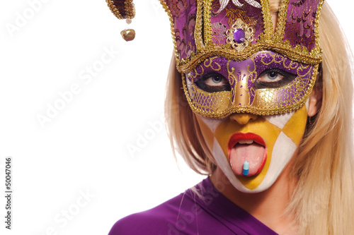 Fotografie woman in violet mask with blue pill on tongue