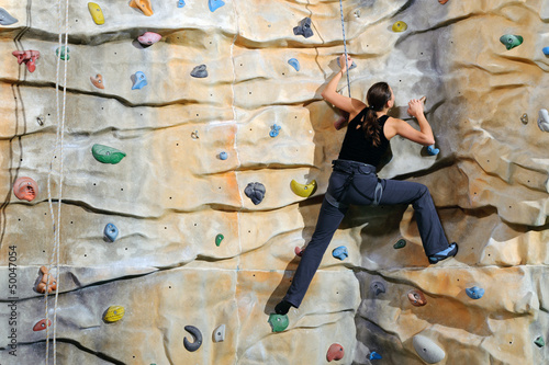 woman on rock wall in sport centre
