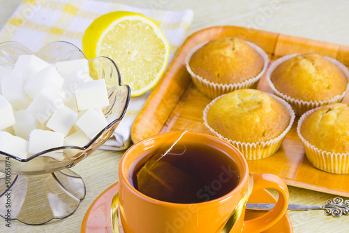 sweet vanilla domestic cakes, tea, lemon and vase with sugar