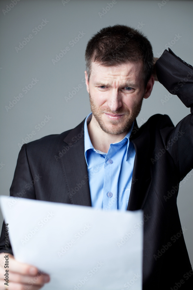 Stressed businessman reading document Stressed businessman reading document