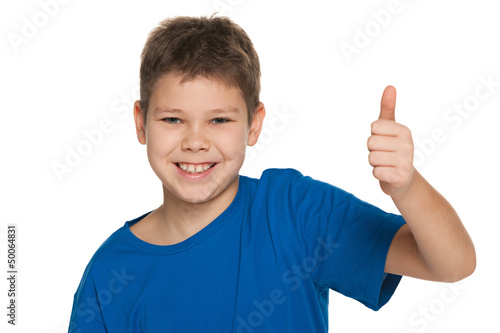 Smiling boy in blue shirt holding his thumb up