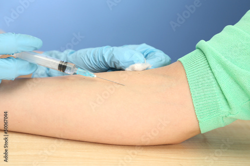 Doctor holding syringe with a vaccine in the patient hand,