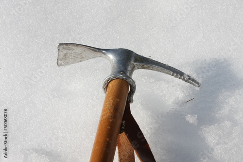 Toy axe stuck in the cold snow in the mountains in winter photo