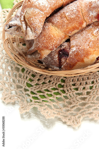 Taste croissants in basket isolated on white. © Africa Studio
