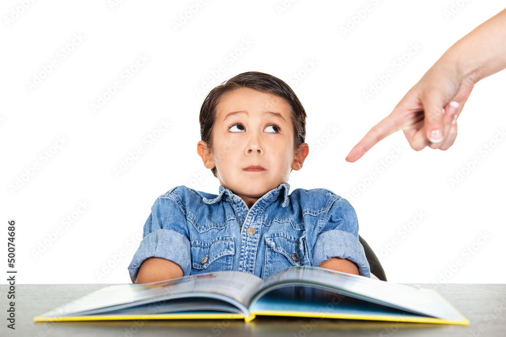 Frightened little boy looks at a finger that points to homework Frightened little boy looks at a finger that points to homework