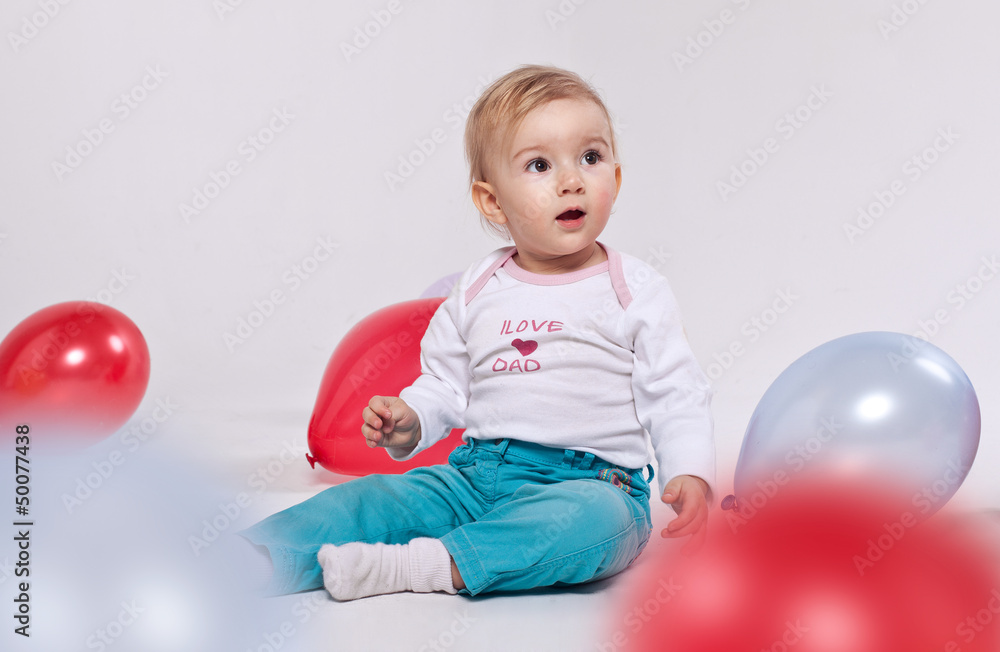 A small girl playing with balloons