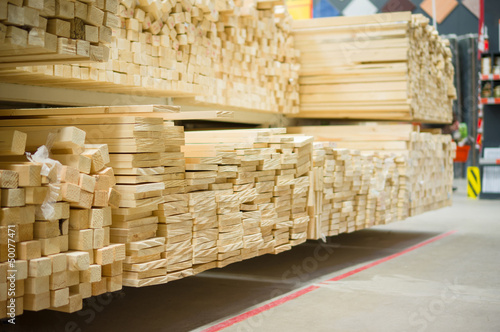Lumber boards and beams of different sizes lie on racks and pall