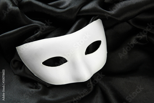 White mask, on black silk fabric photo