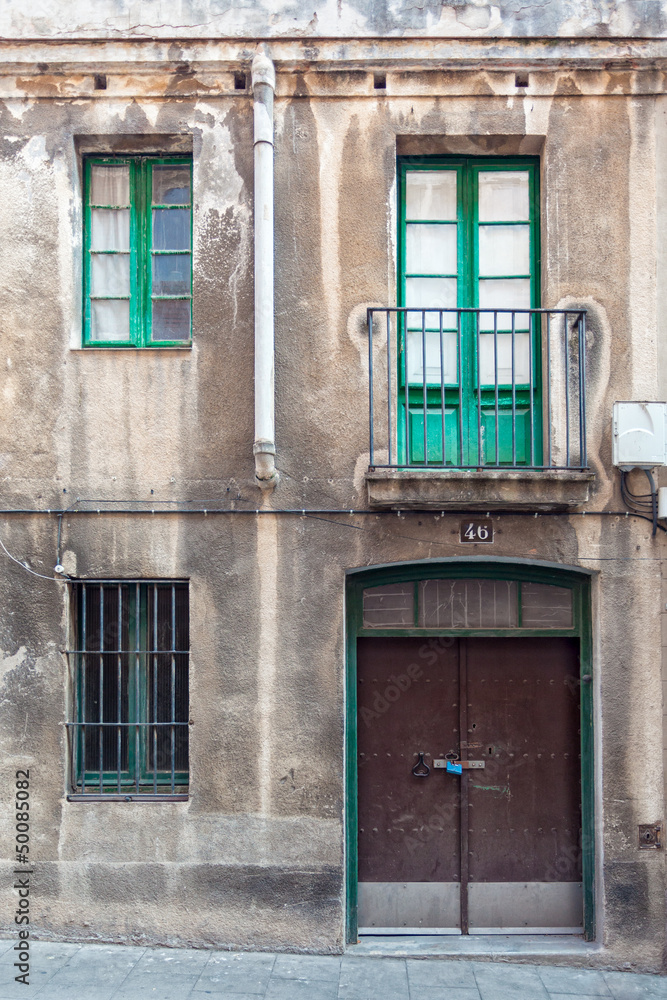 Facade with metal door, windows and balcony Facade with metal door, windows and balcony