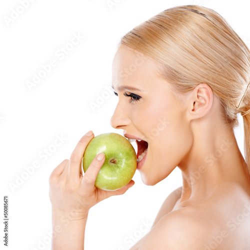 Side view of blond woman she bites an apple