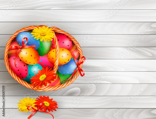 Easter background with color easter eggs in basket on wooden tab