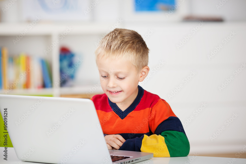 kleiner junge schaut auf laptop kleiner junge schaut auf laptop
