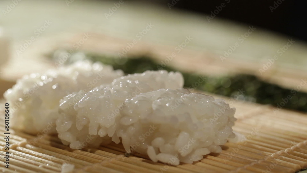 Putting wasabi on the nori while cooking sushi rolls. Putting wasabi on the nori while cooking sushi rolls.