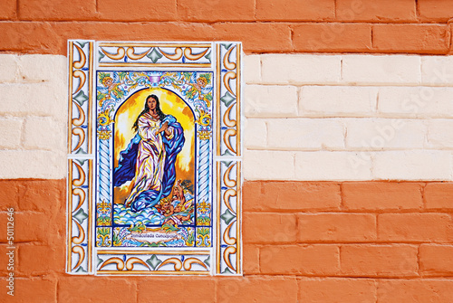 Virgen María en azulejos de cerámica  sobre  pared pintadaa photo