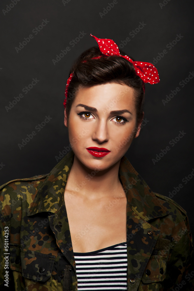 Fototapeta premium Pin-up woman with milytary jacket om black background