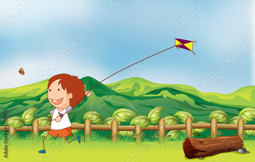 A boy flying his kite at the bridge