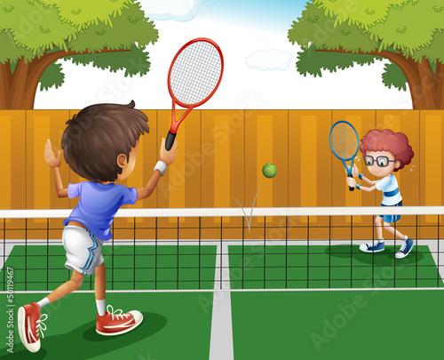 Two boys playing tennis inside the fence
