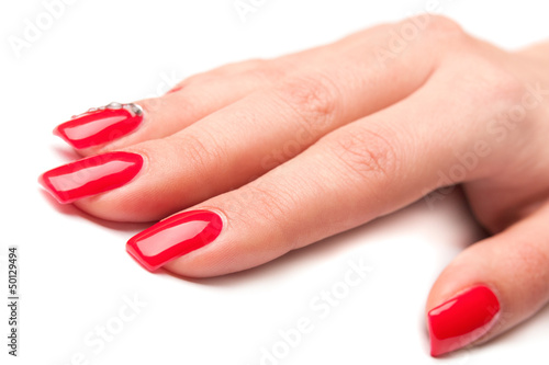 Beautiful female hand with red nails isolated on white