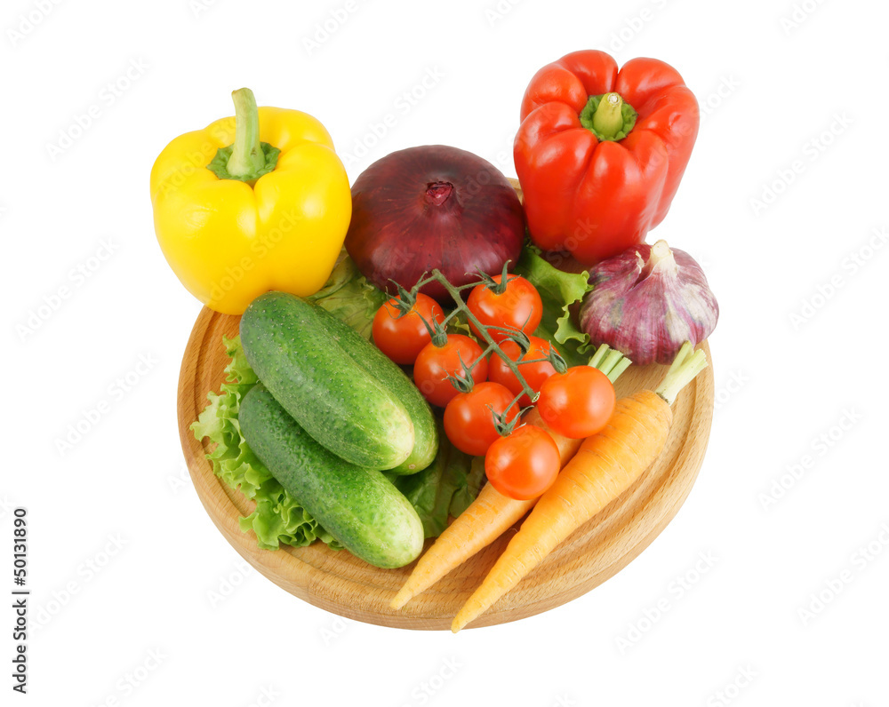 Vegetables on wooden cutting board isolated on white Vegetables on wooden cutting board isolated on white