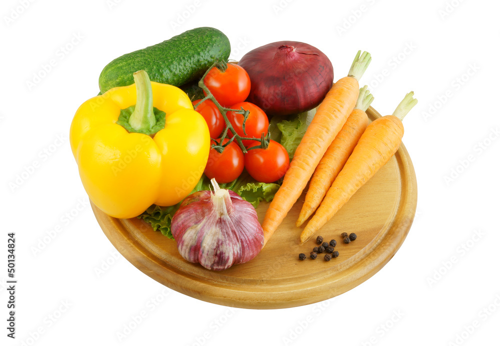 Vegetables on wooden cutting board isolated on white Vegetables on wooden cutting board isolated on white