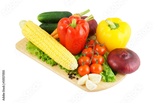 Vegetables on wooden cutting board isolated on white