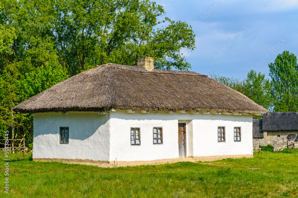 A typical antique Ukrainian country house with a thatch roof, in Pirogovo near Kiev	