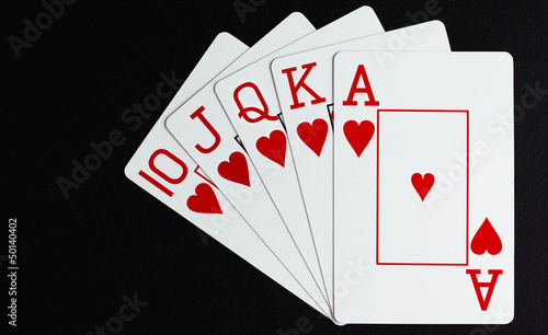 Obraz na plátně Royal flush of hearts over black background