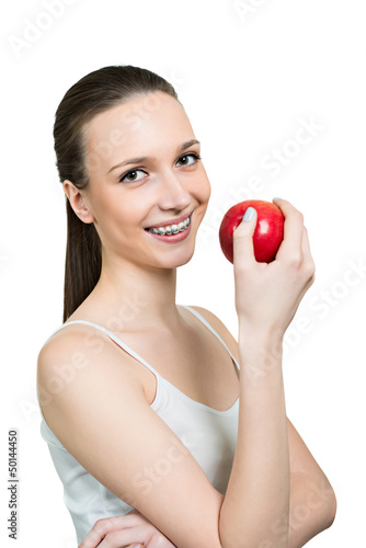 Young woman with apple and brackets on teeth