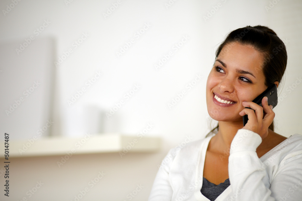 Smiling woman speaking on cellphone looking right Smiling woman speaking on cellphone looking right