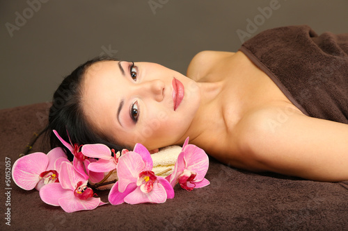 Beautiful young woman in spa salon  on dark background