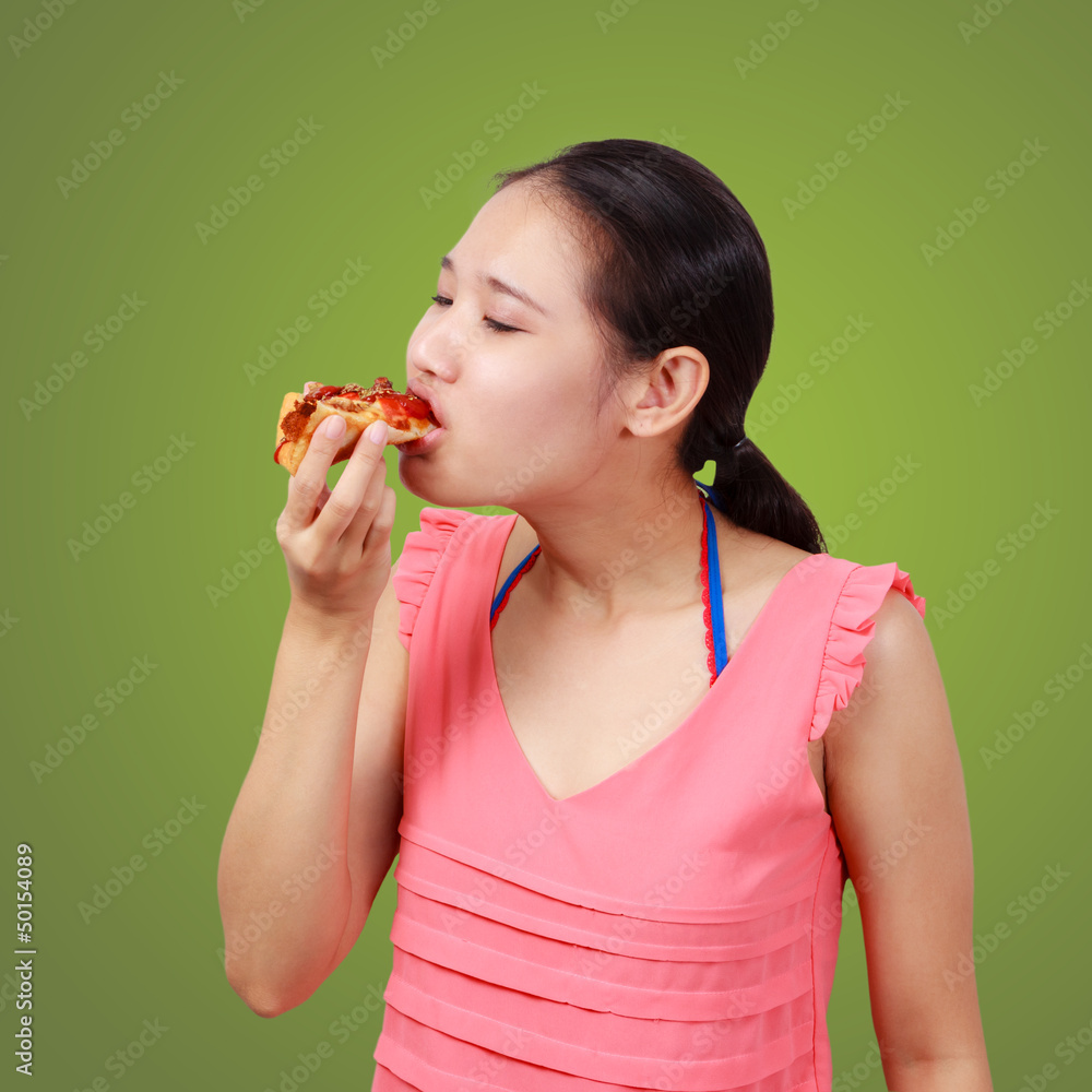 Asian woman eating a piece of tasty pizza