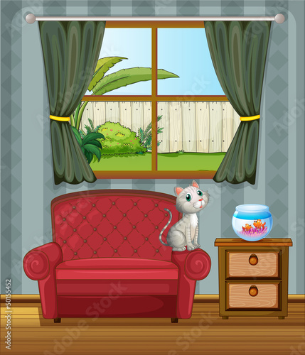 A cat at the sofa watching the fish in the aquarium