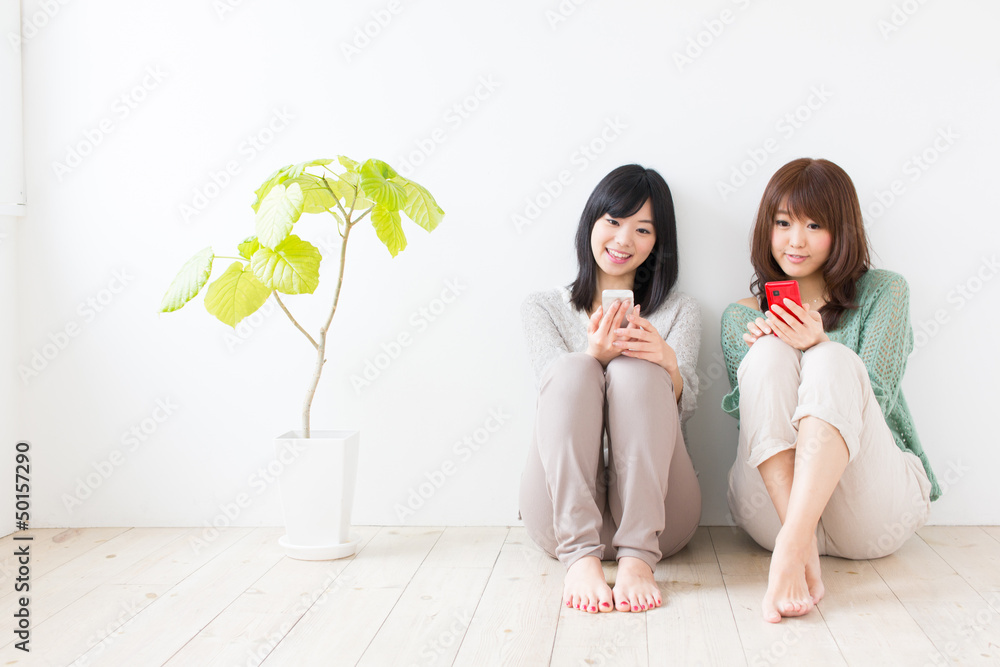 attractive asian women using smart phone in the room attractive asian women using smart phone in the room