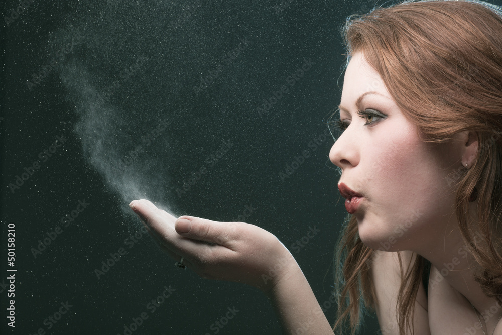 The girl blows off a dust from a palm The girl blows off a dust from a palm