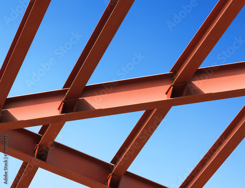 Fotografie Steel beams against the blue sky. Fragment construction site.