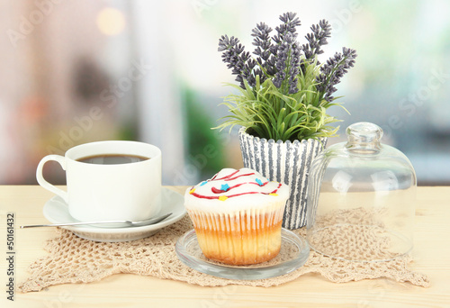 Cupcake on saucer with glass cover, on bright background